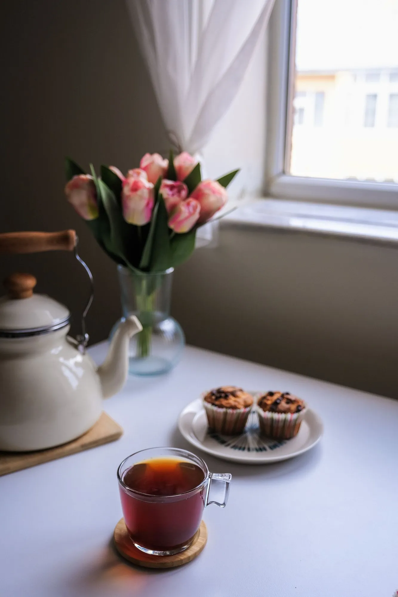 Tea and muffins on the writing table by the window