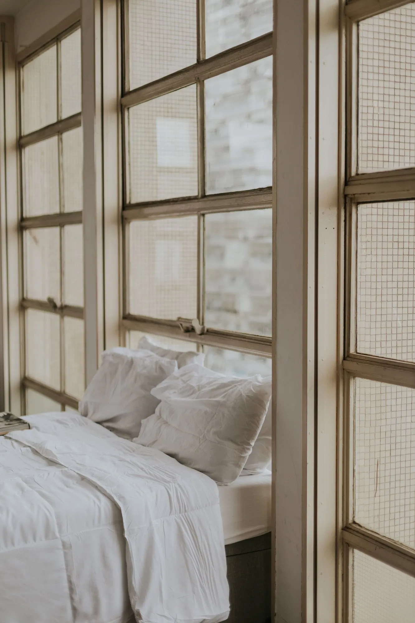 The Lantern, white bedding beside a run of tall paned windows